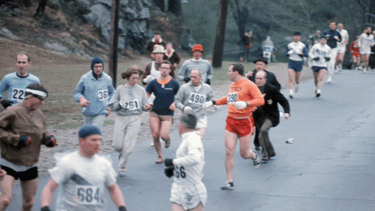 Boston-Marathon 1967: Renn­direktor Jock Semple (rechts, in der blauen Jacke) versucht Kath­rine Switzer (261) zu packen, ihr Freund Tom Miller (390) und Coach Arnie Briggs (490) geben ihr Geleitschutz.