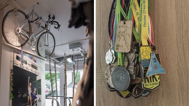 Ein Rennrad, ein Ironman-Plakat und etliche Medaillen zeugen von sportlicher Expertise.