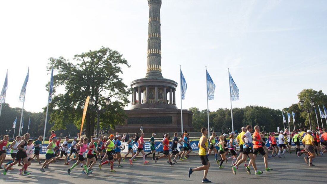 Eine Gruppe Läufer beim Marathon in Berlin um die Friedenssäule