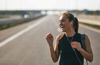 Female jogger listening to music while preparing for run