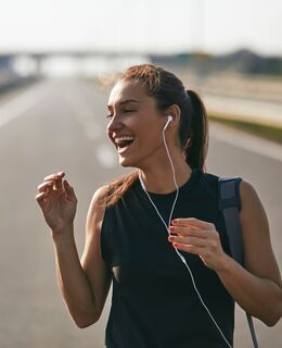 Female jogger listening to music while preparing for run