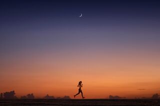 Frau läuft alleine im Dunkeln