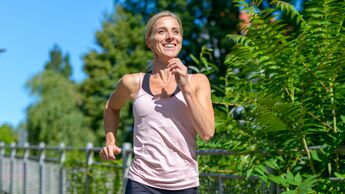 Happy healthy woman jogging outdoors