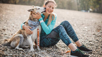 Joggen mit Hund: Eine Läuferin schmust nach dem Lauftraining mit ihrem Hund.
