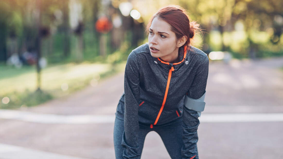 Junge Frau ist nach dem Lauftraining erschöpft.