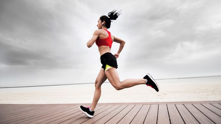 Junge Frau mit definierten Muskeln beim Lauftraining