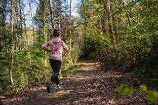 Läuferin im Frühling auf einem Waldweg