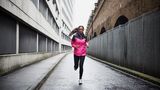 Langer Lauf in der Halbmarathon-Vorbereitung: Eine junge Frau läuft durch eine einsame Straße in der Stadt.