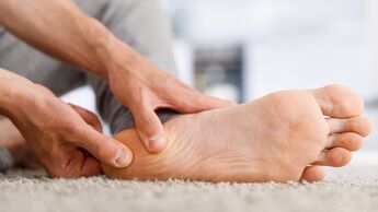 Man hands giving foot massage to yourself after a long walk