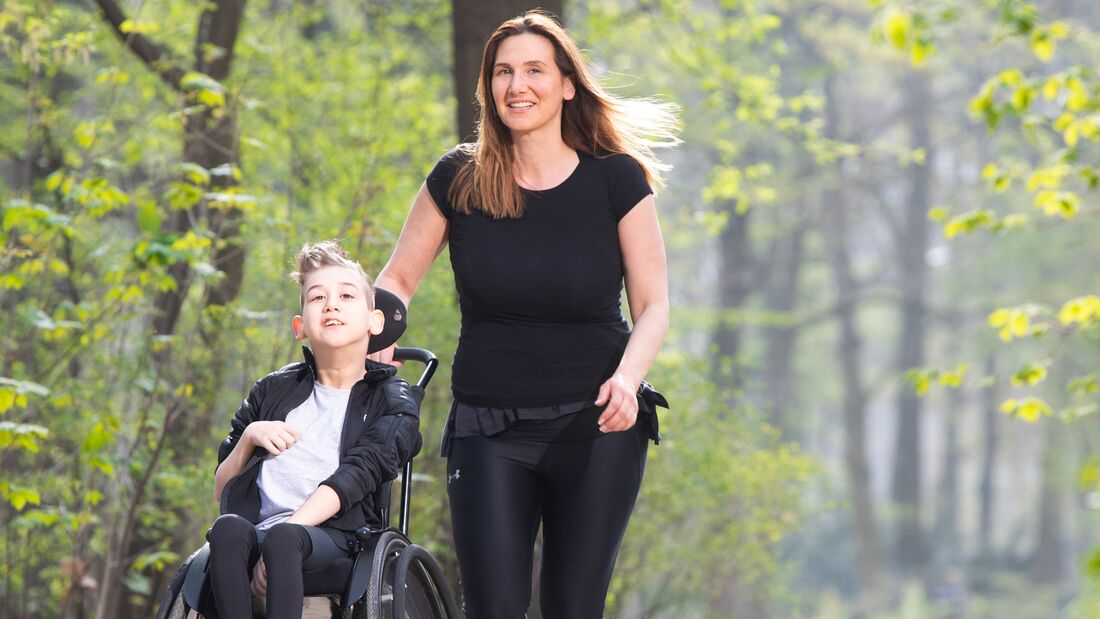 Yasmine Beyaz läuft mit ihrem Sohn, der im Rollstuhl sitzt